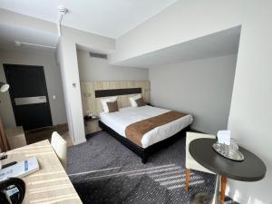 布鲁塞尔最佳西方皇家中央酒店的酒店客房配有一张床铺和一张桌子。