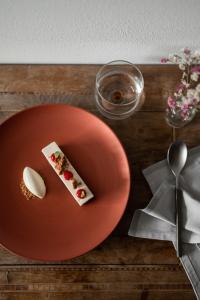 塞纳莱斯Hotel Adlernest的一张红色的盘子,桌子上放着一块食物