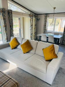 约克Brackencroft Lodge with Hot Tub的客厅配有带黄色枕头的白色沙发