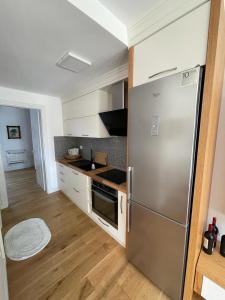 德尔米Sea Gem Apartment的厨房配有不锈钢冰箱和木地板