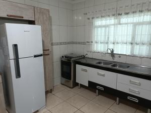 瓜鲁柳斯10 MIN AEROPORTO GUARULHOS的厨房配有白色冰箱和水槽
