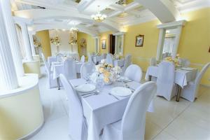 辛菲罗波尔Tavria Hotel的用餐室配有白色的桌子和白色的椅子