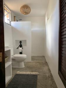 安达Three Little Birds Resort的一间带卫生间和女人雕像的浴室