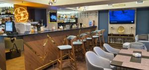 阿特劳Somerset City Centre Atyrau的餐厅内的酒吧配有椅子和柜台
