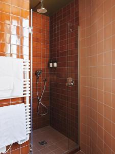 巴黎Hotel Orphée - Orso Hotels的带淋浴的浴室(铺有橙色瓷砖)