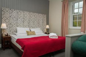 埃斯克代尔伍尔帕克客栈的一间卧室配有一张带红色毯子的大床