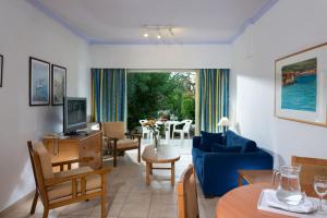 帕福斯帕福斯花园假日度假酒店的客厅配有蓝色的沙发和桌子