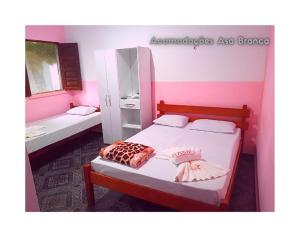 索雷阿萨布兰卡旅馆的一间卧室设有两张床和粉红色的墙壁