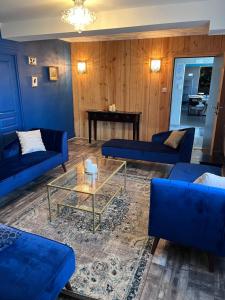 Saint-Michel-Mont-MercureL'hostellerie de Sèvremont的客厅配有蓝色的沙发和桌子