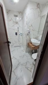 维丁Hotel Ponti的一间带水槽的浴室和白色大理石地板。
