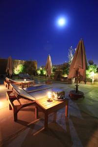 马拉喀什阿尔卡萨Spa庭院旅馆的露台在晚上提供桌子和遮阳伞