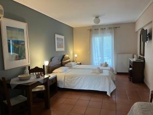 加拉希德松Mira Mare Hotel, Galaxidi的卧室配有一张白色的大床和一张桌子