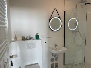 不来梅港Weser-Traum的白色的浴室设有水槽和镜子