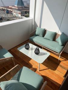 不来梅港Weser-Traum的阳台设有两张沙发、一张桌子和一个窗户。