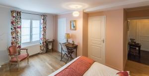 索米尔Couette et café Saumur的卧室配有床、椅子和窗户。
