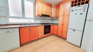 耶克拉Apartamento Alameda Garden的厨房配有橙色橱柜和白色冰箱