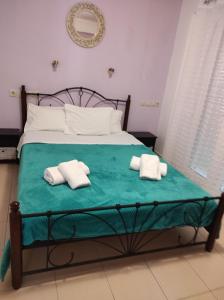 斯卡拉拉乔伊Elena's Suite的一间卧室配有一张床,上面有两条毛巾