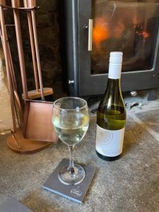 比迪福德Lotte’s Cottage的一杯白葡萄酒,旁边是一瓶葡萄酒