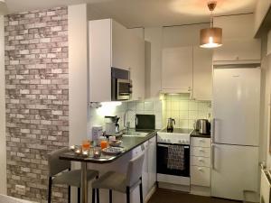 罗瓦涅米卡萨北极公寓的厨房配有白色橱柜和一张带饮品的桌子。