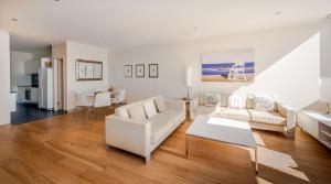 麦夸里港沙堡公寓的客厅配有白色家具和桌子