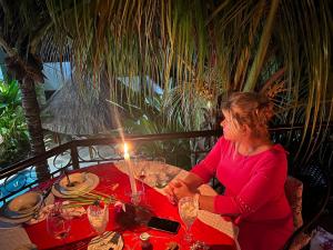 塔马索波Refugio Huasteco Hotel Boutique的坐在桌子上的带蜡烛的女人
