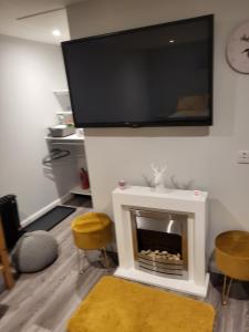 因弗内斯Beautiful studio chalet in the Highland的客厅设有壁炉,墙上配有平面电视。