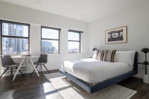 西雅图Reside Seattle Downtown, a Wyndham Residence的卧室配有床、桌子和窗户。