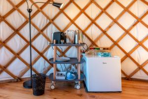 棕榈滩Awaawa - Rangi Yurt的蒙古包内的一个房间,配有冰箱和两个架子