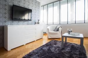 华沙斯维托克里兹斯卡公寓的客厅配有电视、椅子和桌子