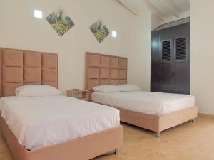 圣玛尔塔Hotel Los Veleros Santa Marta的卧室内的两张床,墙上有心