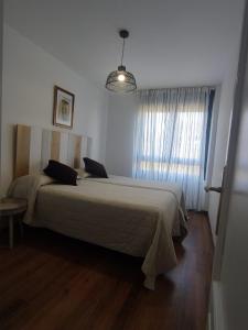 索托德拉马里纳Apartamento 6 personas Playa de Covachos的一间带一张大床的卧室,位于带窗户的房间内