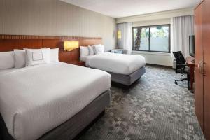 拉古纳山拉古娜希尔斯橙县尔湾万怡酒店的酒店客房设有两张床和电视。