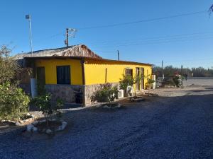洛雷托Loreto La Regional的土路旁的黄色房子