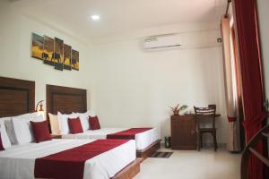 阿努拉德普勒Divine Villa的酒店客房设有两张床和一张桌子。