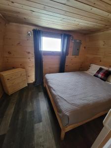 拉马巴耶Motel Le Riviera的小木屋内一间卧室,配有一张床