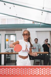 黄金海岸冲浪者背包客巴兹旅舍的女人拿着乒乓球拍