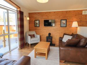 温德米尔Ramblers' Rest Lodge的带沙发和木墙的客厅