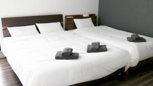 读谷村MONOCHROME -SEVEN Hotels and Resorts-的两张毛巾和两张床