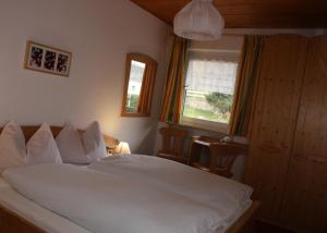 圣杰内肖阿泰西诺雪绒花雷特霍夫旅馆的卧室配有白色的床和窗户。