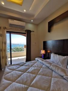 亚喀巴Nice View Hotel فندق الأطلالة الجميلة للعائلات فقط的一间卧室设有一张大床和大窗户