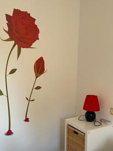 昆卡Apartamento Beatriz的红玫瑰花在墙上,有红灯