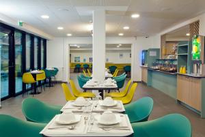 巴涅奥莱Séjours & Affaires Paris Bagnolet的用餐室配有桌子和黄色椅子