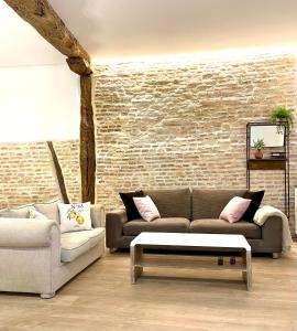 毕尔巴鄂Lauramer Casco Viejo的客厅设有两张沙发和砖墙