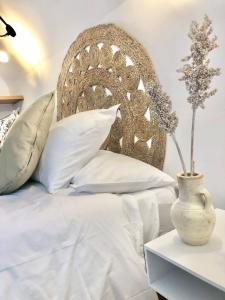 卡拉瓦卡·德·拉·克鲁斯Casa Jaraíz - Centre town的一张带白色枕头和桌子花瓶的床