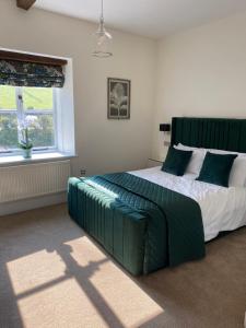 GlasburyBlack Mountain Lodge的一间卧室配有一张大床和绿色床头板