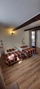 Argoules奥伯格杜格罗斯提勒尔酒店的铺有木地板的客房内的两张床