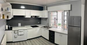卡尔达斯·德·雷斯La Veiga 54的厨房配有白色橱柜和黑白电器