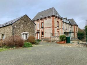 Gouville-sur-MerGîtes grands groupes - Château des Forges Gouville的一座大型砖砌建筑,前面有门