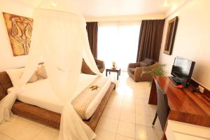维拉港美拉尼西亚维拉港酒店的一间卧室配有一张白色天蓬床