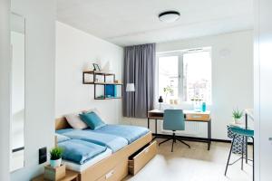 格但斯克MILESTONE Gdańsk Center的一间卧室配有蓝色的床和一张书桌
